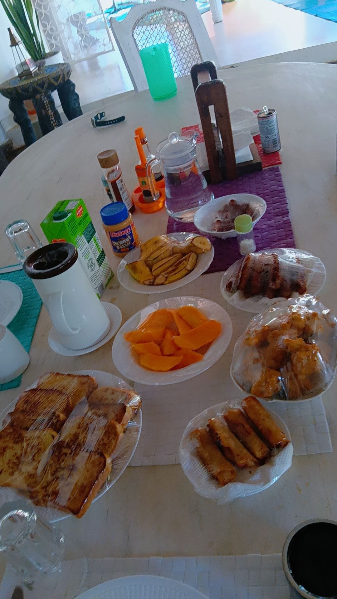 Full Kenyan breakfast spread with plantains, mango, beignets, and hot tea by Chef Angie