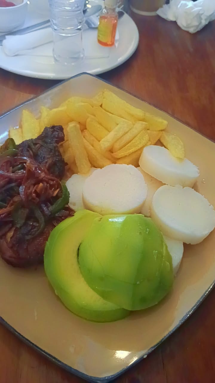 Chef Angie's plate with chicken, ugali, fries and avocado on the side